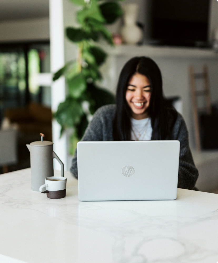 Woman happily looking at her laptop feeling the results of Online DBT Therapy