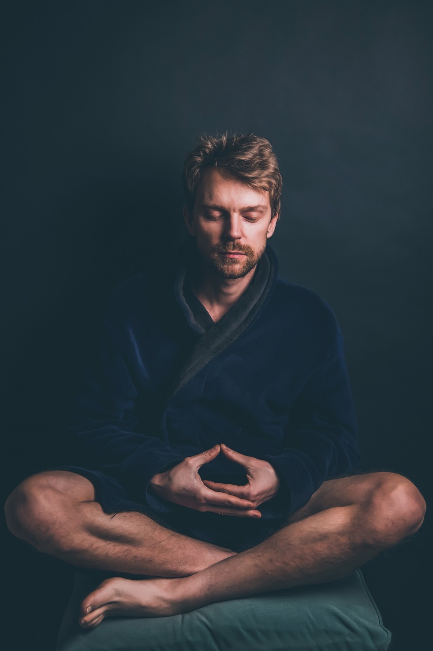 Man sitting on a couch in a darkened room stressed needing DBT Therapy